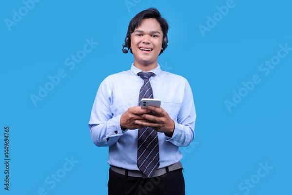 Obraz Portrait of customer support phone sales operator in headset holding mobile phone.