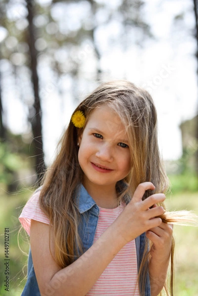 Fototapeta Cute smiling preschool girl with dandelion in her hair outdoors