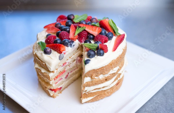Fototapeta Delicious raspberry cake with fresh strawberries, raspberries, blueberry, currants 