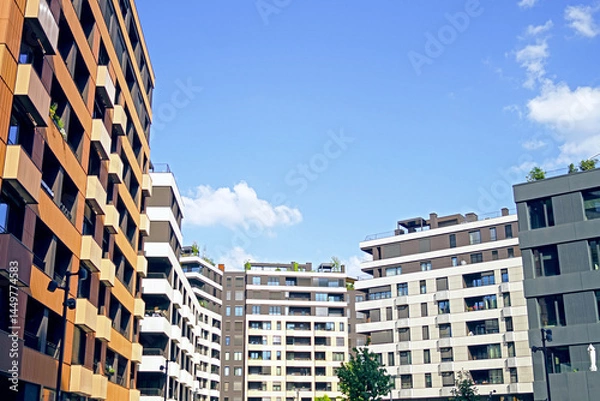 Fototapeta A first-person view of the courtyard of a modern urban area: a cityscape with multi-apartment residential buildings in the same style. Planned development: buying real estate in a housing complex.