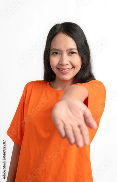 Obraz A woman smiling and offering palm hand giving assistance and acceptance.