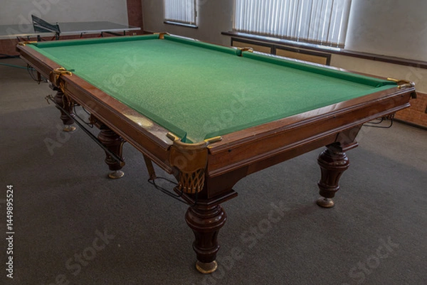 Fototapeta Billiard table with green baize. Billiard room. Board game. Billiard club for relaxing in your free time. Billiard table lighting.