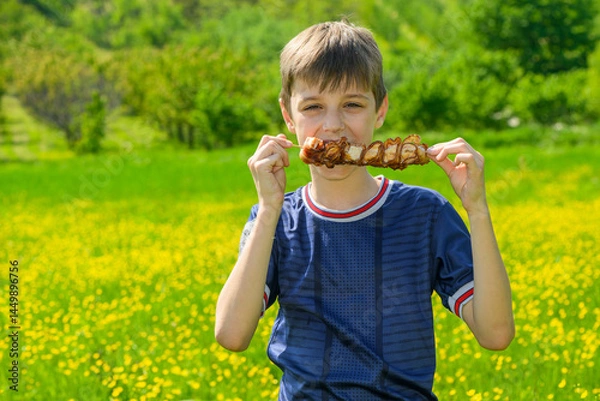 Obraz The boy is holding skewers and is about to eat them. Skewer (Serbian: Raznjici) is a popular Serbian specialty of grilled meat, equivalent of the Greek souvlaki and Turkish şaşlık.