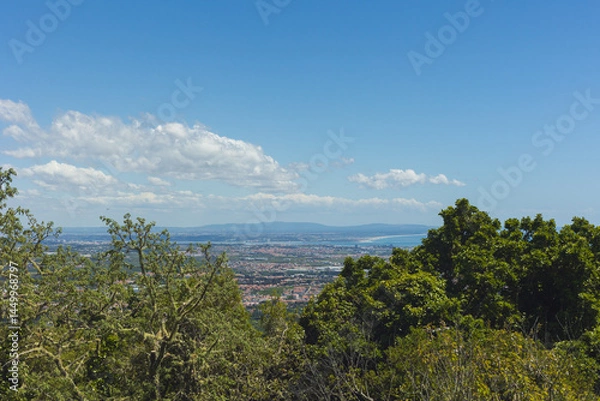 Fototapeta Panoramic view from Santa Eufémia in Sintra, Portugal, capturing the vast coastal landscape with blue skies, urban areas, and the Atlantic Ocean on a clear sunny day.