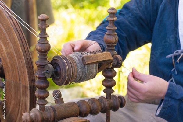 Obraz Close-up of spinning wheel and thread spool in artisan's hands