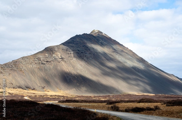 Fototapeta View of mountain peak with shadows formed by clouds in the Hvalfjarðarsveit of Western Iceland