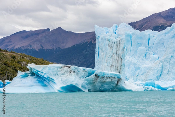 Fototapeta Patagonia famous glacier Perito Moreno in Argentina. Blue ice blocks falling in the lake at the bottom of huge patagonian glacier, part of the Patagonia ice fields. Lake full of icebergs