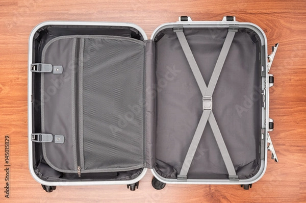 Fototapeta Otwarta pusta torba podróżna na drewnianej podłodze