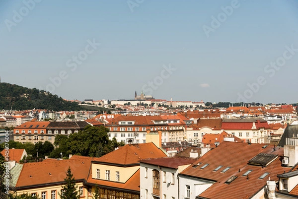 Fototapeta Panoramic view over Prague with orange rooftops and blue sky