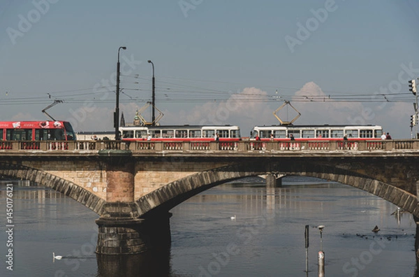Fototapeta Historic bridge in Prague with red trams