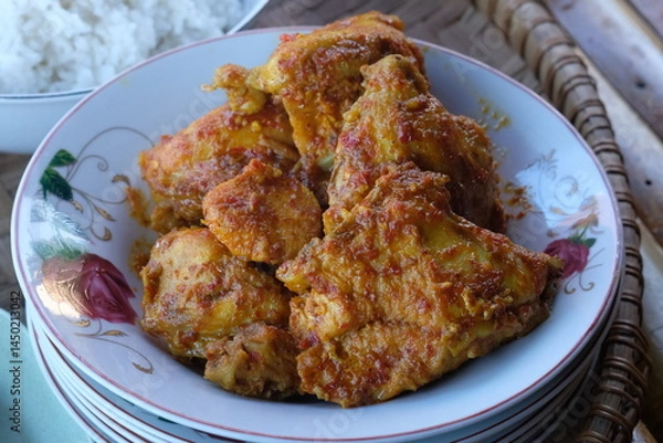 Fototapeta spicy balado chicken on a plate. spicy chicken seasoned with chili, turmeric, ginger, shallots, garlic. balado ayam.