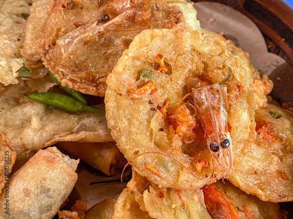 Obraz Gorengan fried Bakwan udang on a plate served with green chili peppers is traditional authentic typical snack from Java.