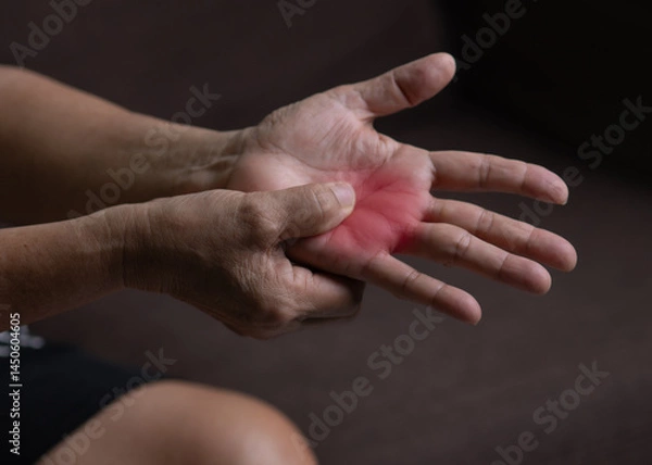 Fototapeta Trigger Finger, Senior woman's left hand massaging her ring finger, Suffering from pain, Close up and macro shot, Health care concept