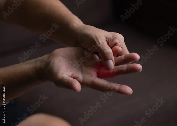 Fototapeta Trigger Finger, Senior woman's left hand massaging her ring finger, Suffering from pain, Close up and macro shot, Health care concept