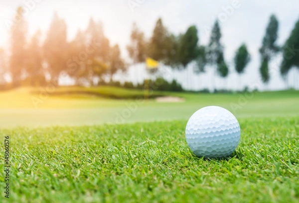 Obraz Golf ball on golf course, flag as background.