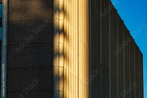Fototapeta Modern Building Facade with Sunlit Textures and Architectural Details