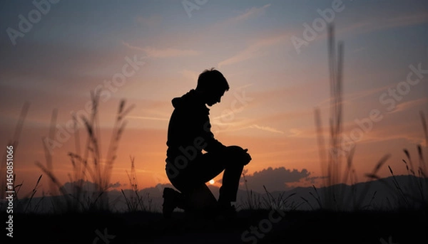 Fototapeta Silhouette of Contemplation at Dusk: A solitary figure kneels in silhouette, silhouetted against a vibrant sunset, evoking introspection and solitude. Reflecting on the serenity of the moment.