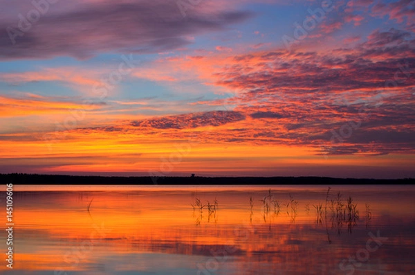 Fototapeta Colorful down sky over the lake in summer.