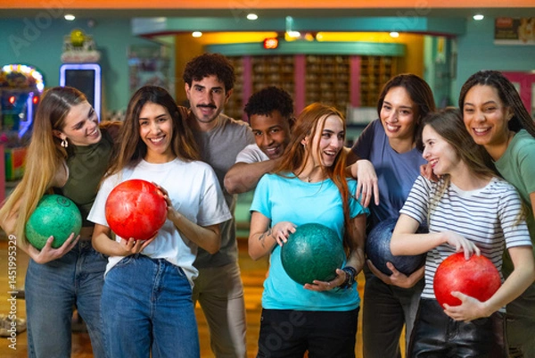 Obraz Group of young people having fun, holding bowling balls, ready to play