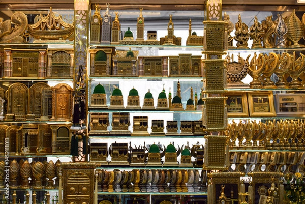 Obraz Madinah, Saudi Arabia - March 3, 2025: A golden miniature souvenir of the Prophet's Mosque and the Kaaba is displayed in a shop, as a gift for Hajj and Umrah pilgrims.
