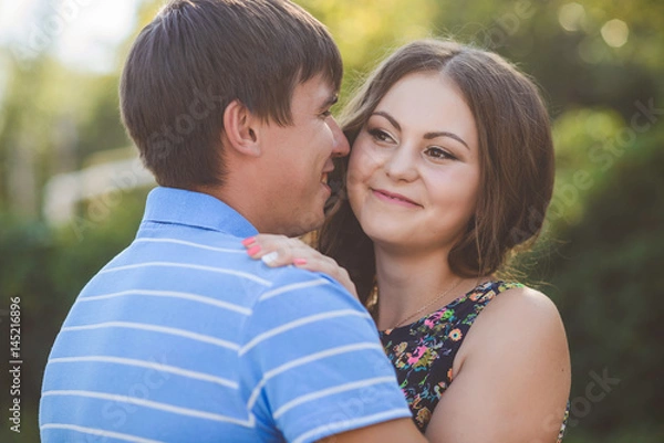 Fototapeta Couple in love hugging against the background of nature. Closeup