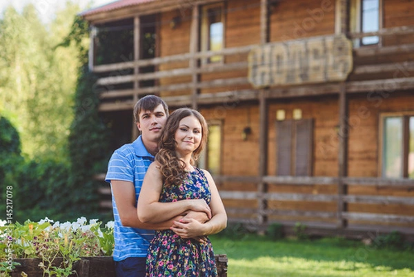 Fototapeta Romantic young couple hugging each other on the background of the hotel in a rustic style.