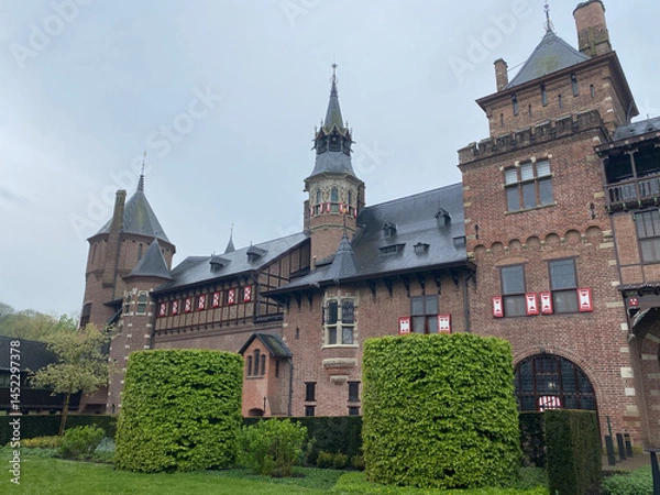 Fototapeta Exterior view of the majestic De Haar Kastel in the Netherlands, showcasing its impressive towers, moats, and red-brick architecture