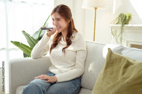 Fototapeta woman talking with AI via smartphone at home