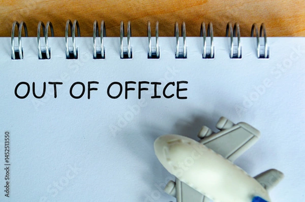 Fototapeta Out Of Off text on white notepad with small airplane. Out of office concept and getaway.