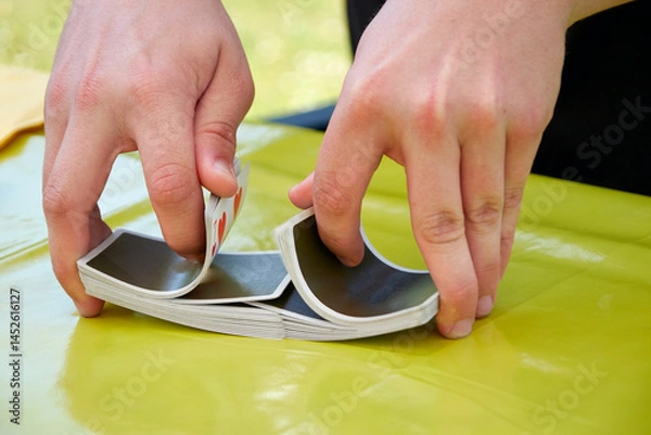 Fototapeta Shuffle playing cards with hands