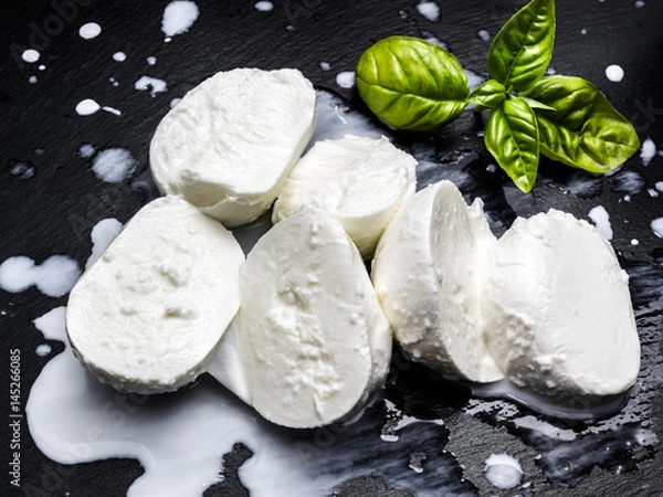 Obraz Świeża mozzarella z fiordilatte z bazylią na łupku czarnego łupka