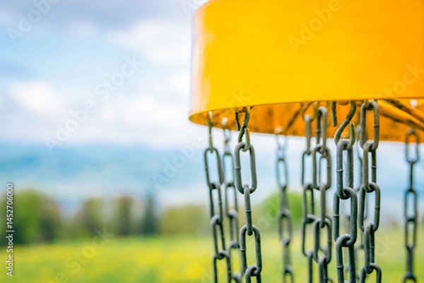 Obraz yellow disc golf basket with blurred background