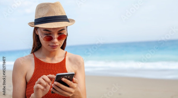 Fototapeta woman using smart phone at the beach