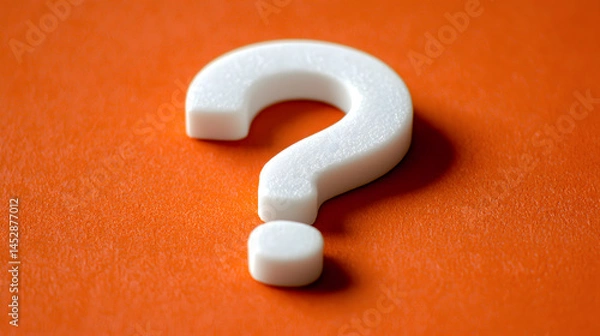 Fototapeta A Curious Question: A pristine, white question mark rests boldly against a vibrant, orange backdrop, inviting contemplation.