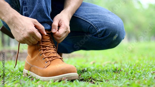 Obraz Men are tying a shoelace