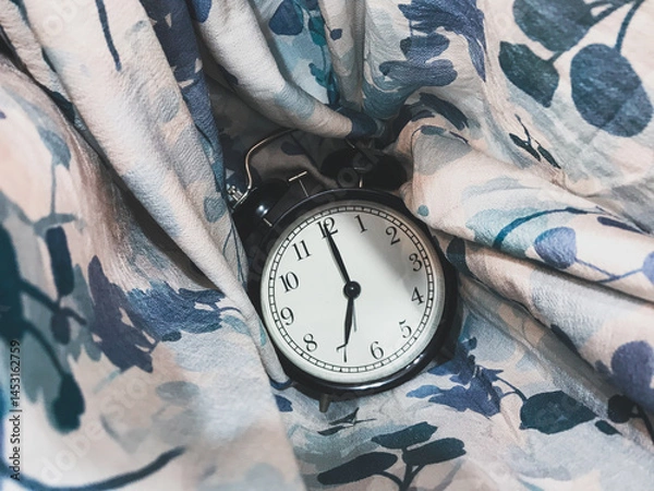 Fototapeta 7 o’clock alarm clock with a backdrop of abstract fabric