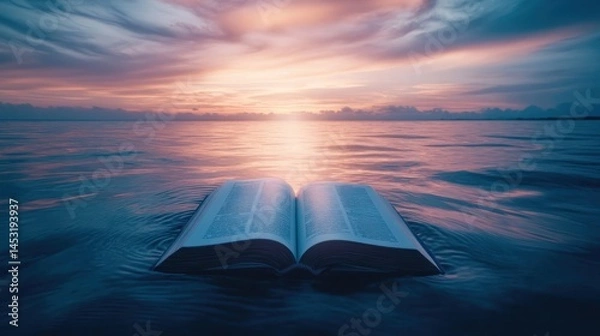 Fototapeta Open book floats on tranquil water at sunrise.  Vast, vibrant sky above