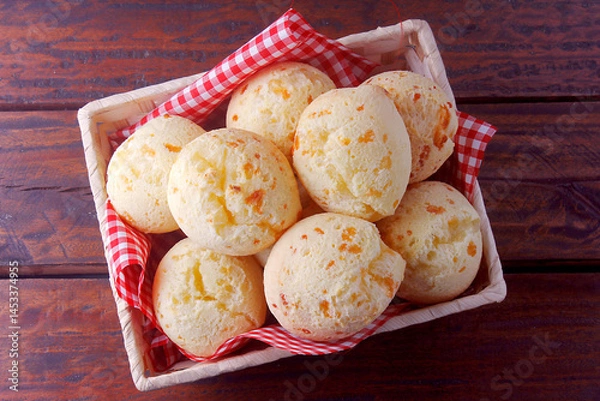 Fototapeta homemade cheese bread, traditional Brazilian snack, in the basket on a rustic kitchen table