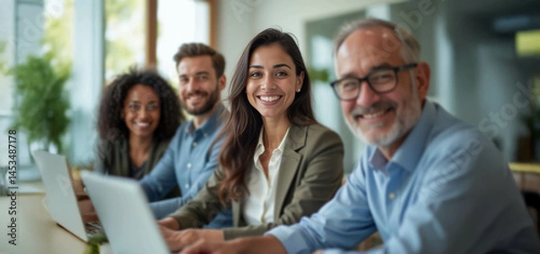 Fototapeta A diverse group of confident professionals smiling in a bright modern office, exuding positivity and tech-savvy collaboration.
