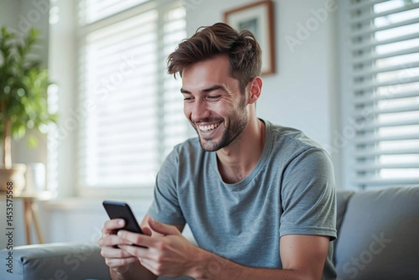 Fototapeta Happy man guy using smartphone at Home, smile and hold phone on he hand with internet technology use of shopping, search, chat, message at inddor living room with beautiful natural light