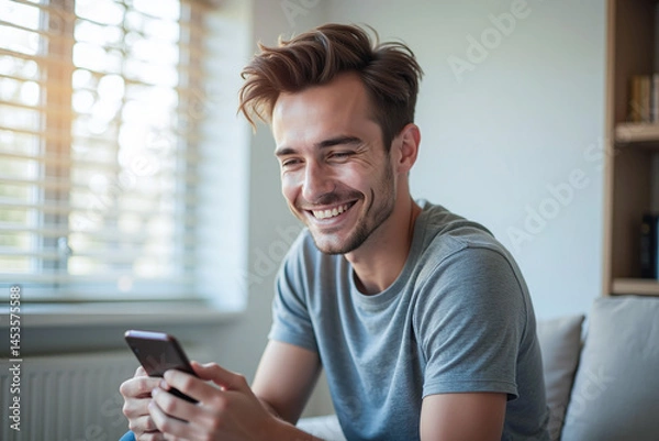 Fototapeta Happy man guy using smartphone at Home, smile and hold phone on he hand with internet technology use of shopping, search, chat, message at inddor living room with beautiful natural light