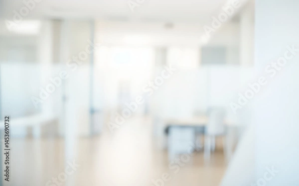 Fototapeta Blurred office interior with desks and partitions in a bright white space.
