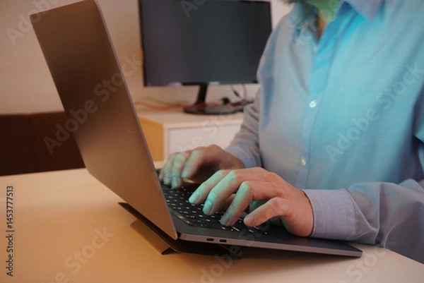 Fototapeta Man Typing on Laptop at Workstation
