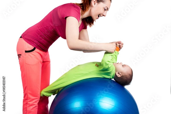 Fototapeta A mother and baby doing gymnastic exercises on the ball. Isolated background