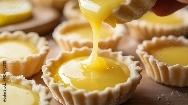 Obraz Tart shells being filled with lemon curd, close up on glossy texture