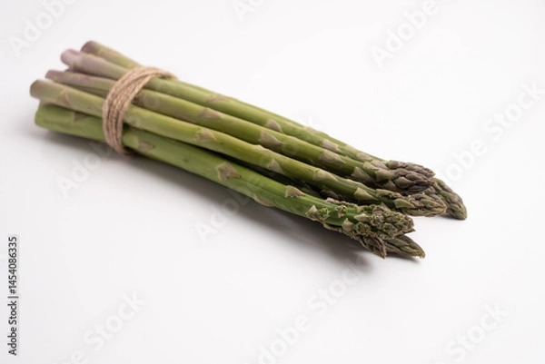 Fototapeta Green asparagus on a light background. Bunch of ripe fresh asparagus. Healthy organic food. Cook at home. Natural vitamins, raw materials for food. Handpicked Bio Asparagus