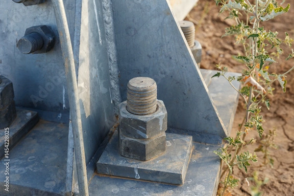 Fototapeta Close up view of a bolt securing an electric transmission line support in a dry landscape