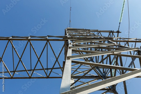 Fototapeta View of high voltage power line insulators against a clear blue sky
