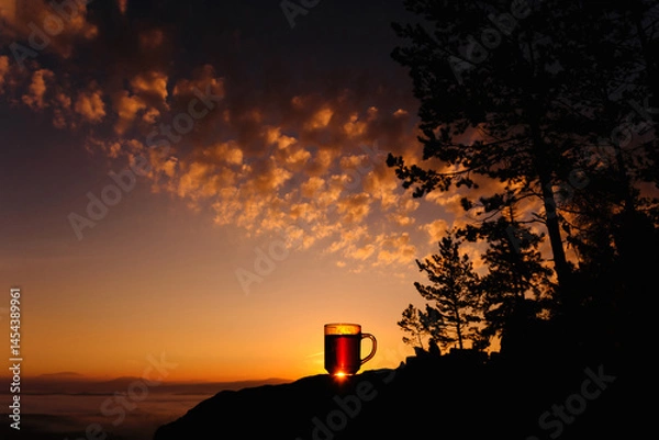 Fototapeta A hot cup of tea at dawn in the mountains.