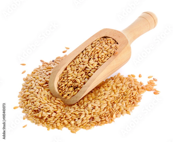Fototapeta Golden flax seeds in a scoop for spices close up isolated on a white background